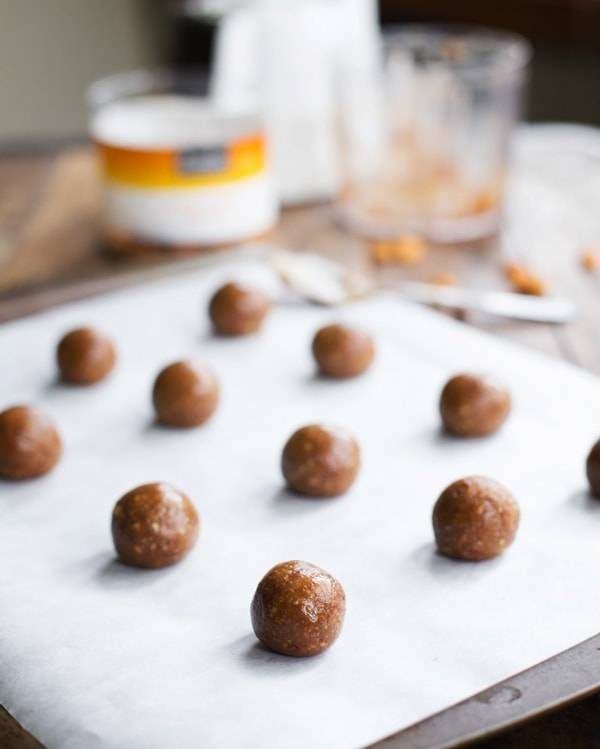 Peanut butter cookie dough balls on parchment paper.