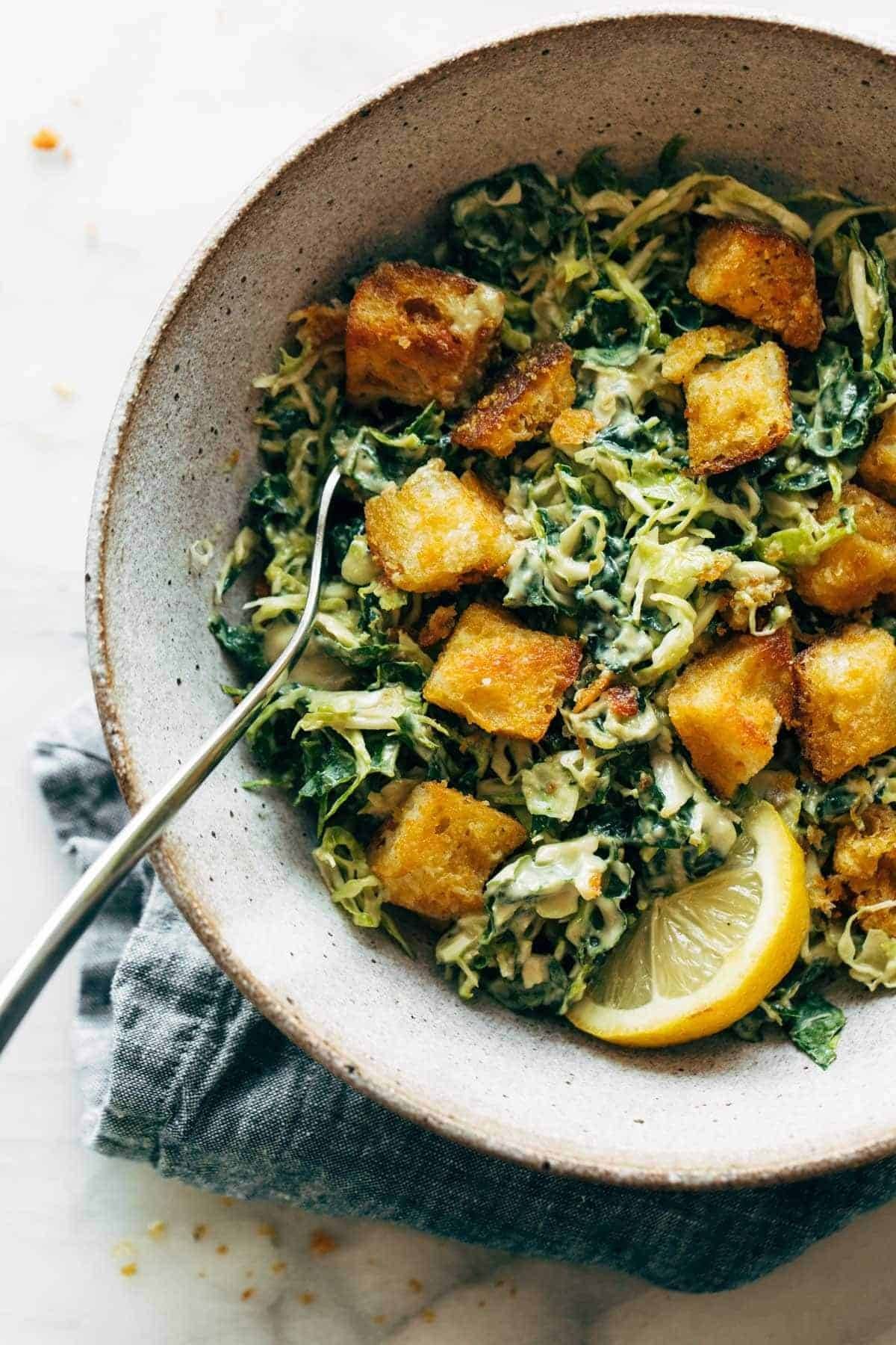 Brussels and kale caesar in a bowl with croutons.