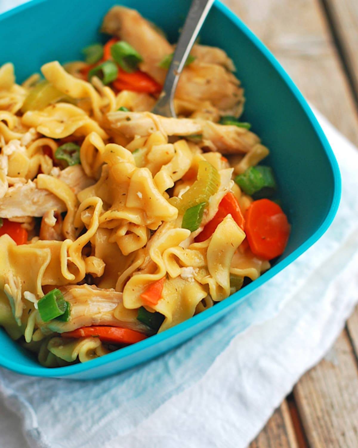 Chicken soup noodles in a blue bowl.